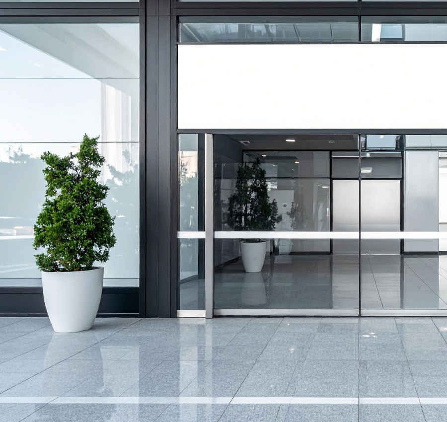 Exterior of an office building with a plant in front